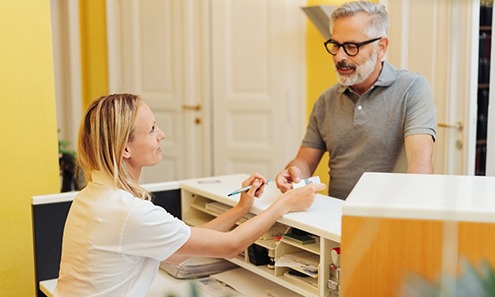 A man paying for dental implants
