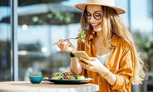 Woman smiling while eating lunch outside